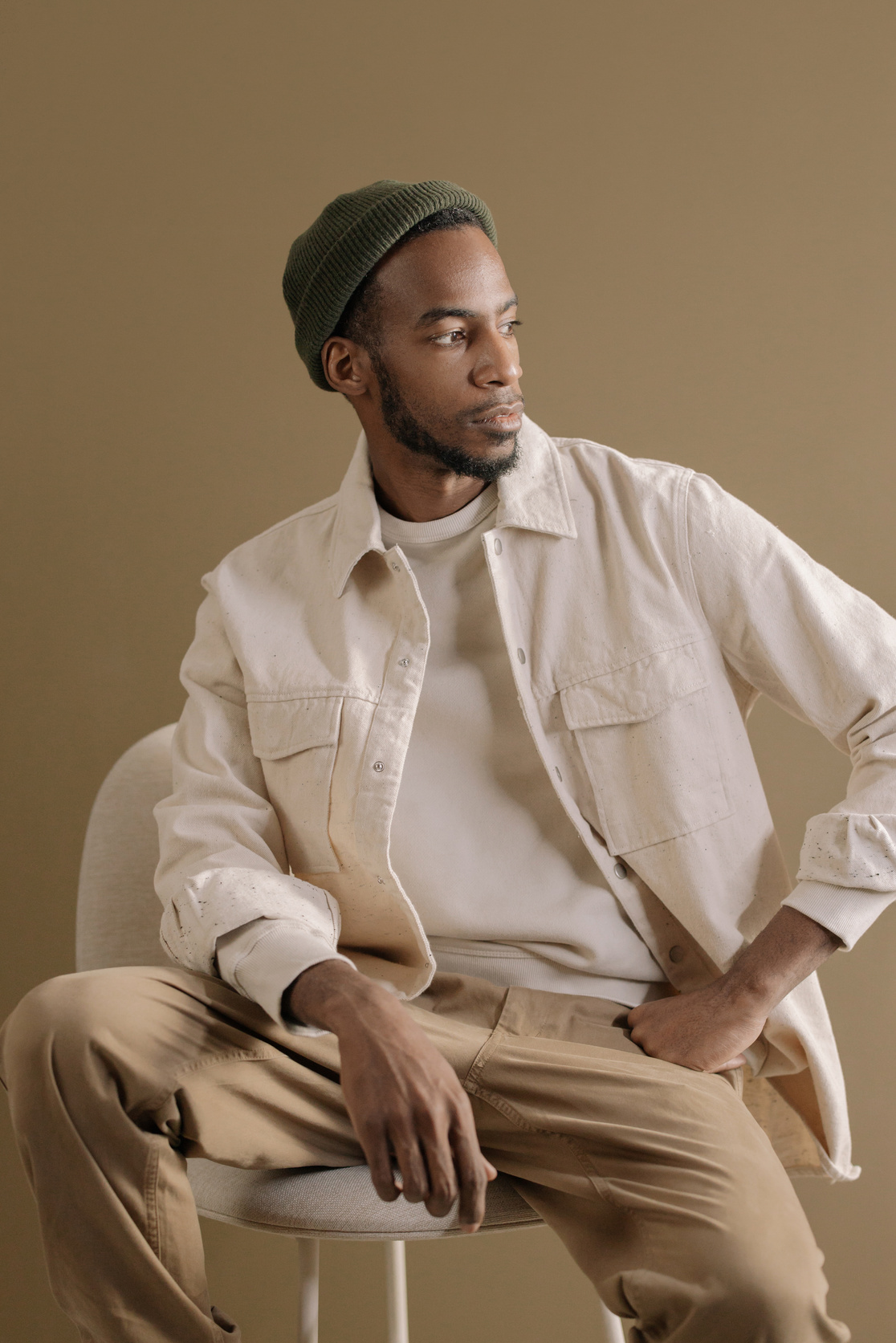 Man Looking Away Sitting on a White Chair 